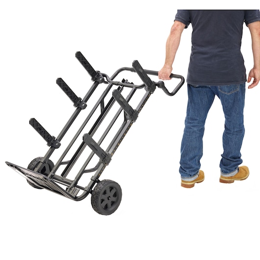 Person using a DEWALT wheeled tool cart with adjustable holders, designed for transporting heavy equipment.