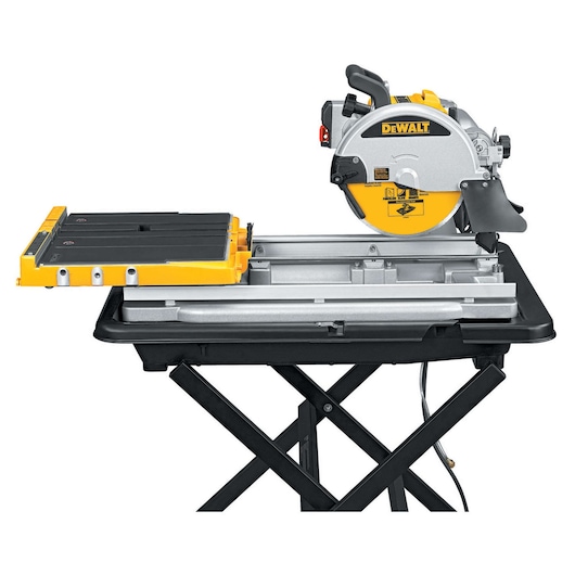 A DEWALT D24000 wet tile saw on a folding stand, featuring a yellow and silver design with a black table surface and a circular saw blade.