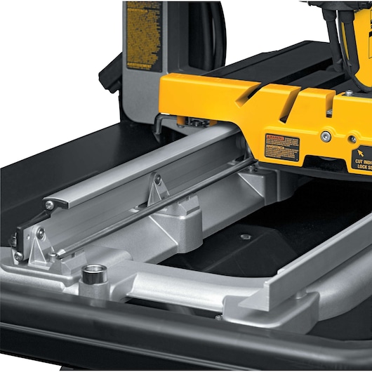 Close-up of a DEWALT D24000 tile saw, showing the sliding guide and yellow frame.