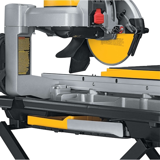 Close-up of a DEWALT D24000 tile saw with yellow blade and sturdy metal frame.