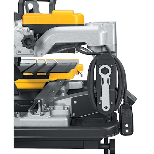Close-up of a DEWALT D24000 wet tile saw showing tool storage, power cord, and part of the cutting table.