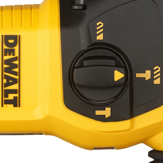 Close-up of DEWALT rotary hammer with yellow body and black mode selector switch.