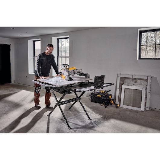 DEWALT D36000-QS, D36000 tile saw on stand in use indoors. Photography category. Tools and accessories visible.