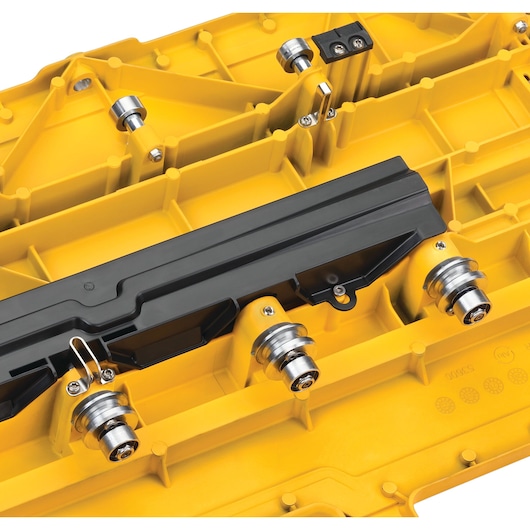 Close-up of yellow DEWALT tool part with metal rollers and black plastic section.