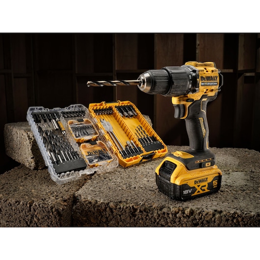 DEWALT cordless drill with drill bit sets in cases, displayed on concrete blocks in a workshop setting.