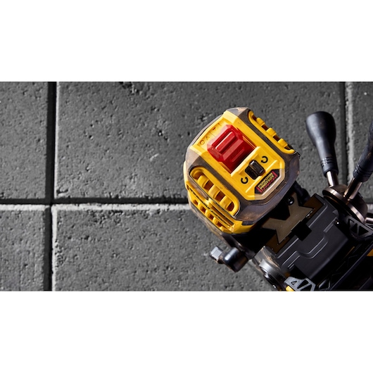 Close-up of a DEWALT DCD1623N tool on a tiled surface, showing its yellow and black design with controls.