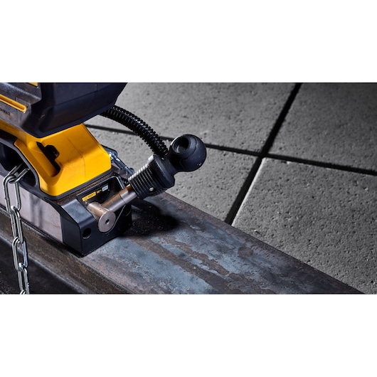Close-up of DEWALT tool secured to a metal beam with a chain. Industrial floor tiles are shown in the background.