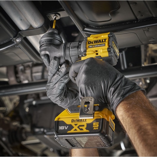 DEWALT 18V tool used under vehicle, SKUs DCD803P2T-QW, DCD803P2T. Close-up, gloved hands in action.