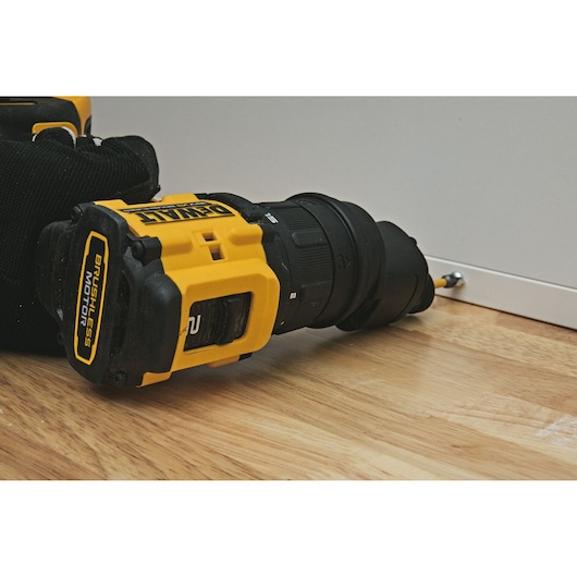 DEWALT drill DCD803P2T-QW, DCD803P2T in use on wood floor, screw to cabinet. Photography product category.