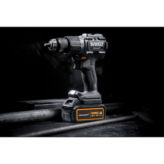DEWALT cordless drill with McLaren branding and 18V battery, shown on a dark industrial surface.