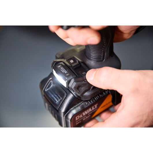 DEWALT DCD86MP2T-QW, DCD86MP2T photography tool close-up in use, person holding device with light on.