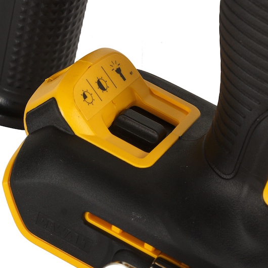 Close-up of a DEWALT power tool showing the light mode switch in yellow and black.