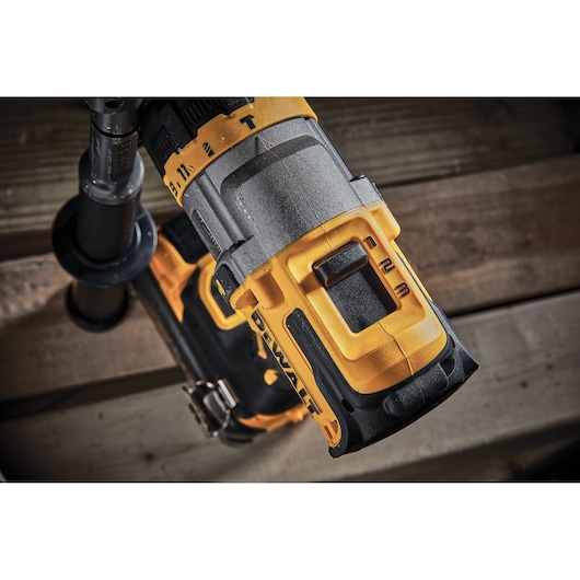Close-up view of a DEWALT cordless drill, showing the yellow and black body, focusing on the gearbox and speed selector switch.
