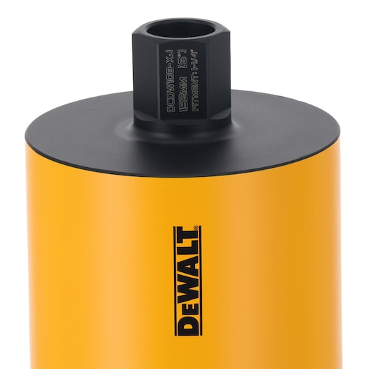 Close-up of a DEWALT yellow cylindrical core drill accessory with black top and branded logo.