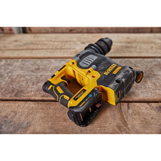 A DEWALT cordless power drill with a yellow and black design, placed on a wooden surface.