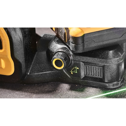 Close-up of DEWALT DCE089D1G18 laser level adjustment knob with yellow details and green laser line.