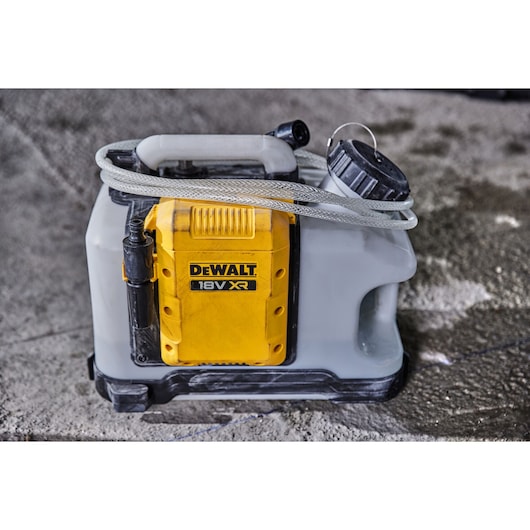 DEWALT Photography sprayer DCE6820N, DCE6820N-XJ shown on ground with hose and handle.