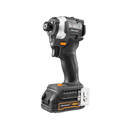 A DEWALT McLaren limited edition cordless impact driver with a black and silver design and orange accents. The tool features a lithium-ion battery and a metal belt clip.