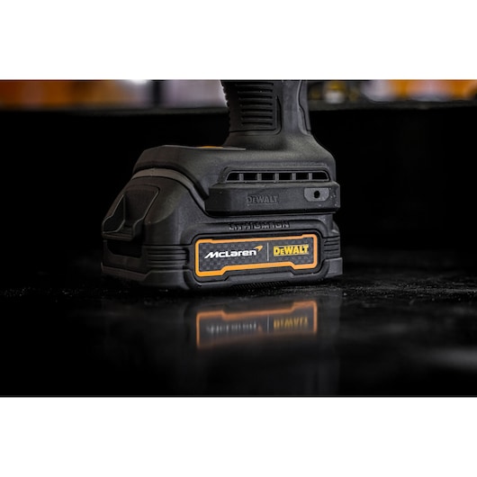 Close-up image of the base of a DEWALT power tool with a McLaren and DEWALT logo, featuring a sturdy black design and textured grip.