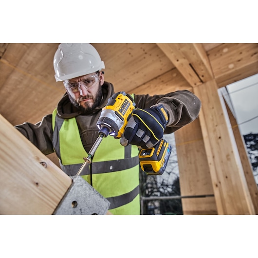 DEWALT tools DCK2201P1T1-XE, DCF860NT used in construction, worker with drill and gloves.
