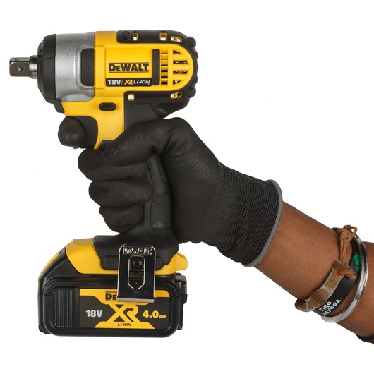 A gloved hand holds a DEWALT 18V XR Li-Ion cordless impact wrench with a 4.0Ah battery.