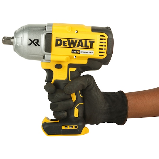 A hand wearing a black glove holding a DEWALT 18V XR brushless impact wrench against a white background.