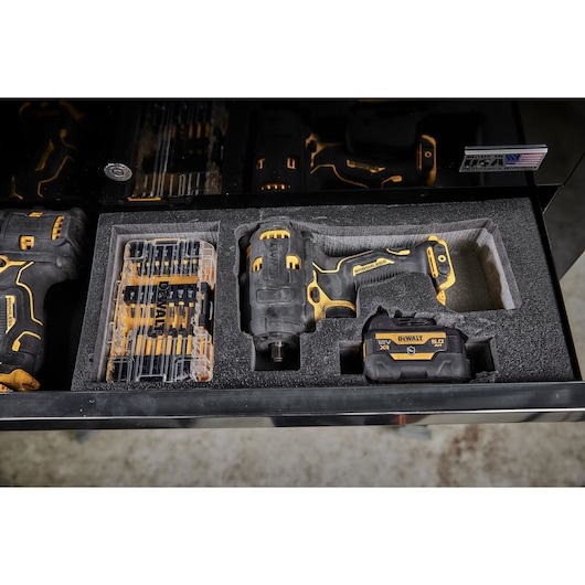 A DEWALT 18V XR cordless impact driver set, including the tool, battery pack, and a drill bit set, stored in a protective foam tool drawer.