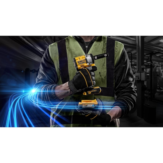 Person in safety vest holding DEWALT impact wrench with glowing blue lines, industrial background visible.