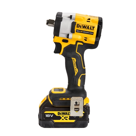 The image shows a DEWALT 18V XR Brushless cordless impact wrench with a yellow and black design. The tool is upright and features a compact body, a sturdy handle with textured grip, and a metal belt clip. The battery is attached at the base.