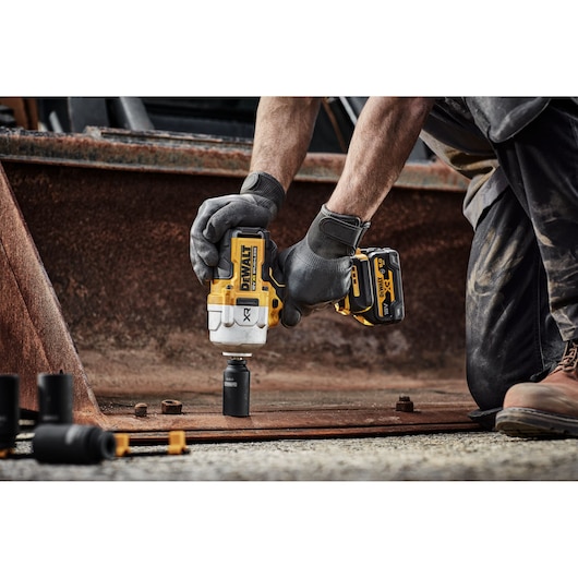 DEWALT DCF961N, DCF961N-XJ impact wrench in use on site. Gloves, rusty metal, sockets visible.