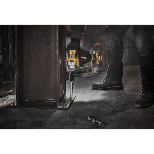 DEWALT DCF961N, DCF961N-XJ impact driver in use fixing bolts to a metal beam on construction site.