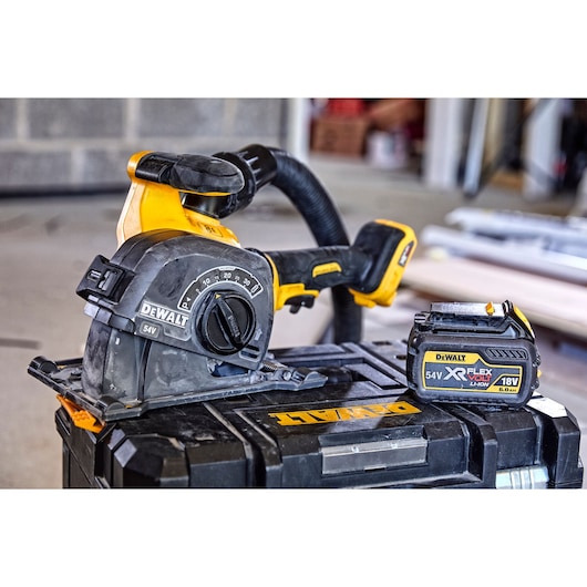 DEWALT cordless power tool and battery on a black case, shown in a workshop setting.