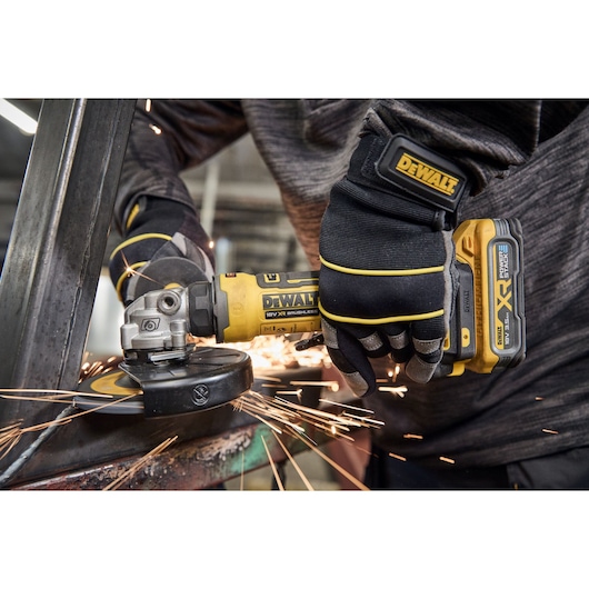 DEWALT tools DCG404NT, DCG404S2T-QW in action, grinding metal with sparks in workshop.