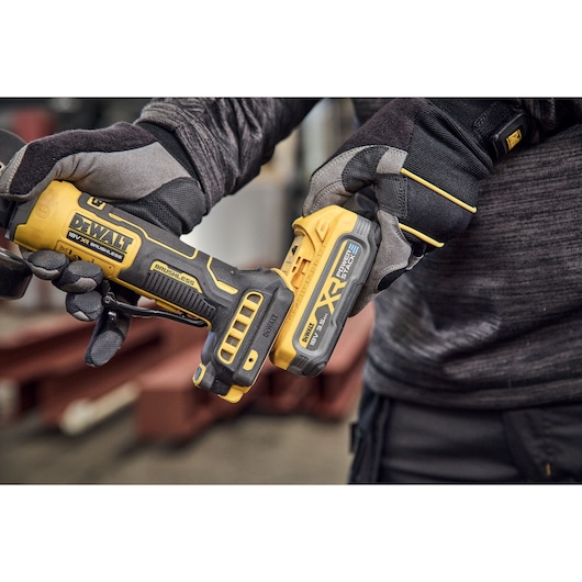 DEWALT power tool in use, model DCG404NT, DCG404S2T-QW, person wearing gloves.
