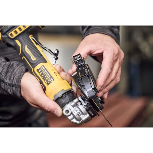 DEWALT grinder DCG404S2T-QW and DCG404S2T in use, close-up of hands attaching disc. Photography category.