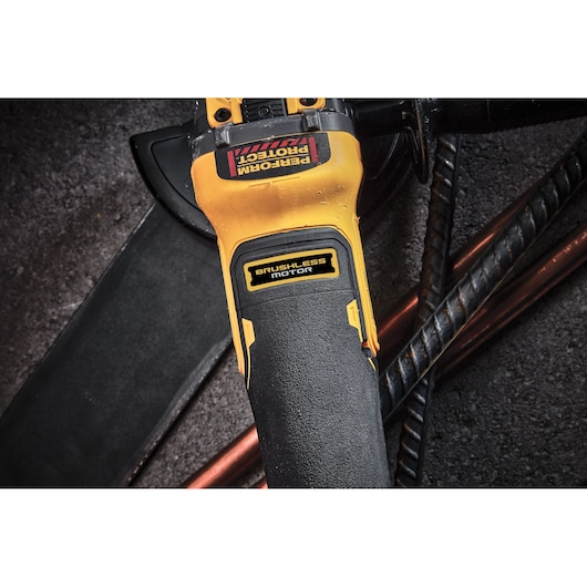 Close-up of a DEWALT brushless motor power tool on a workshop surface with metal rods.