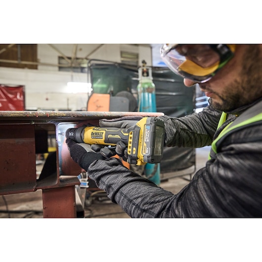 DEWALT DCG420N-XJ, DCG420N grinder used in workshop. Worker in gloves operates tool. Photography category.