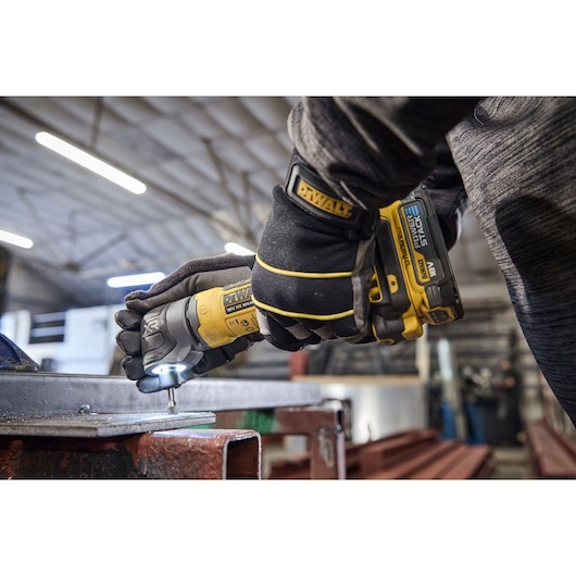 DEWALT DCG421N-XJ, DCG421N grinder used on metal in workshop, worker wearing gloves.