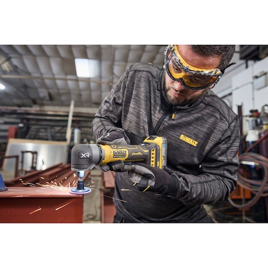 DEWALT DCG421N-XJ, DCG421N in use grinding metal, sparks flying, worker in workshop, Photography category.