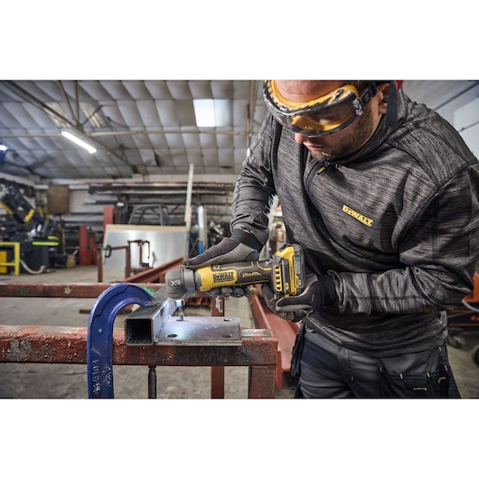 DEWALT DCG421N-XJ, DCG421N in use on metal in workshop. Photography product category.