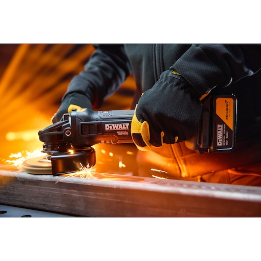 DEWALT grinder in use, model DCG45MP2T-QW and DCG45MP2T, with sparks flying during metal work.