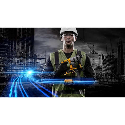 Worker holds a DEWALT DCH172E2T cordless drill at a construction site with modern city buildings in the background.