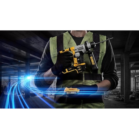 Person holds a DEWALT cordless rotary drill in a construction site setting, bright blue light trails in foreground.