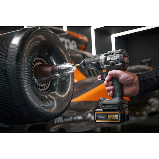 DEWALT DCK200MP2T, DCK200MP2T-XE drill used on car wheel. Photography product close-up.