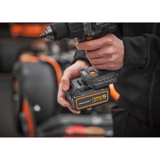 DEWALT drill with McLaren battery, SKUs DCK200MP2T, DCK200MP2T-XE, held by person. Photography category.