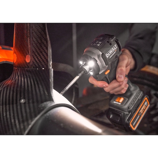 DEWALT tool, DCK200MP2T and DCK200MP2T-XE, used on machinery, close-up with LED light.
