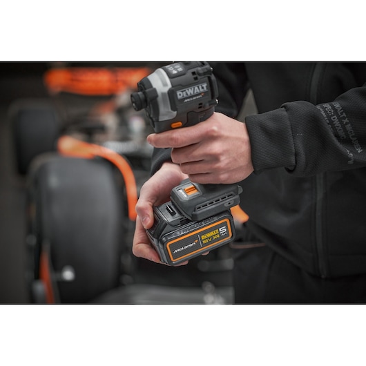 DEWALT DCK200MP2T, DCK200MP2T-XE impact driver held in hand, McLaren edition, 18V battery shown.