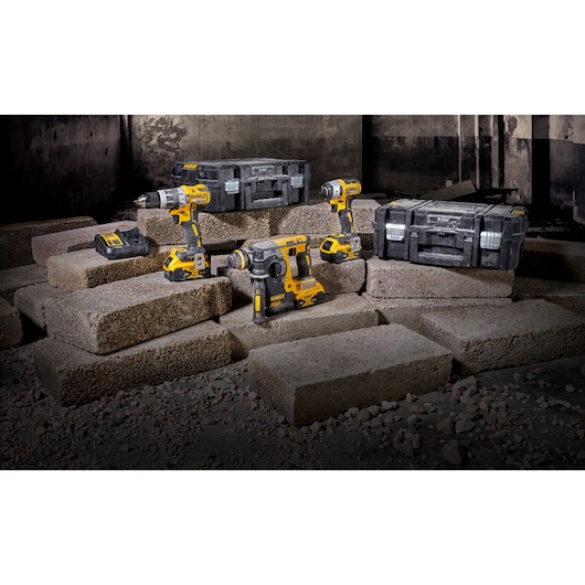 DEWALT power tools and toolboxes arranged on concrete blocks in an industrial setting.