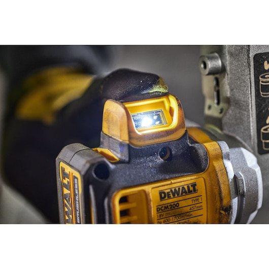 Close-up of DEWALT DCM200NT power tool with LED light, showing label and tool features.