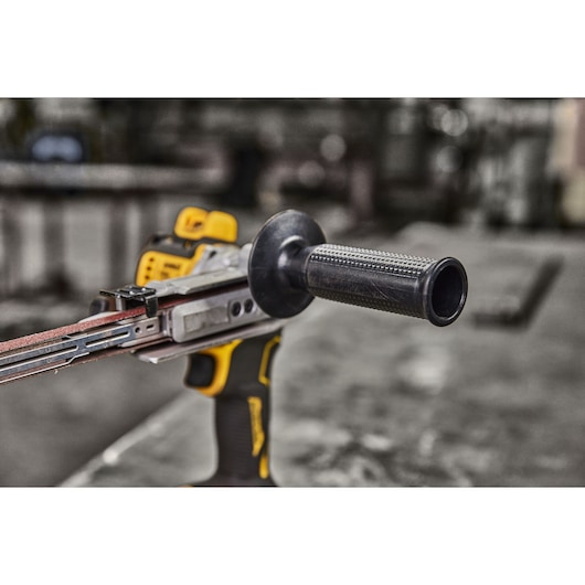 Close-up of a DEWALT cordless belt sander with ergonomic handle in a workshop setting.